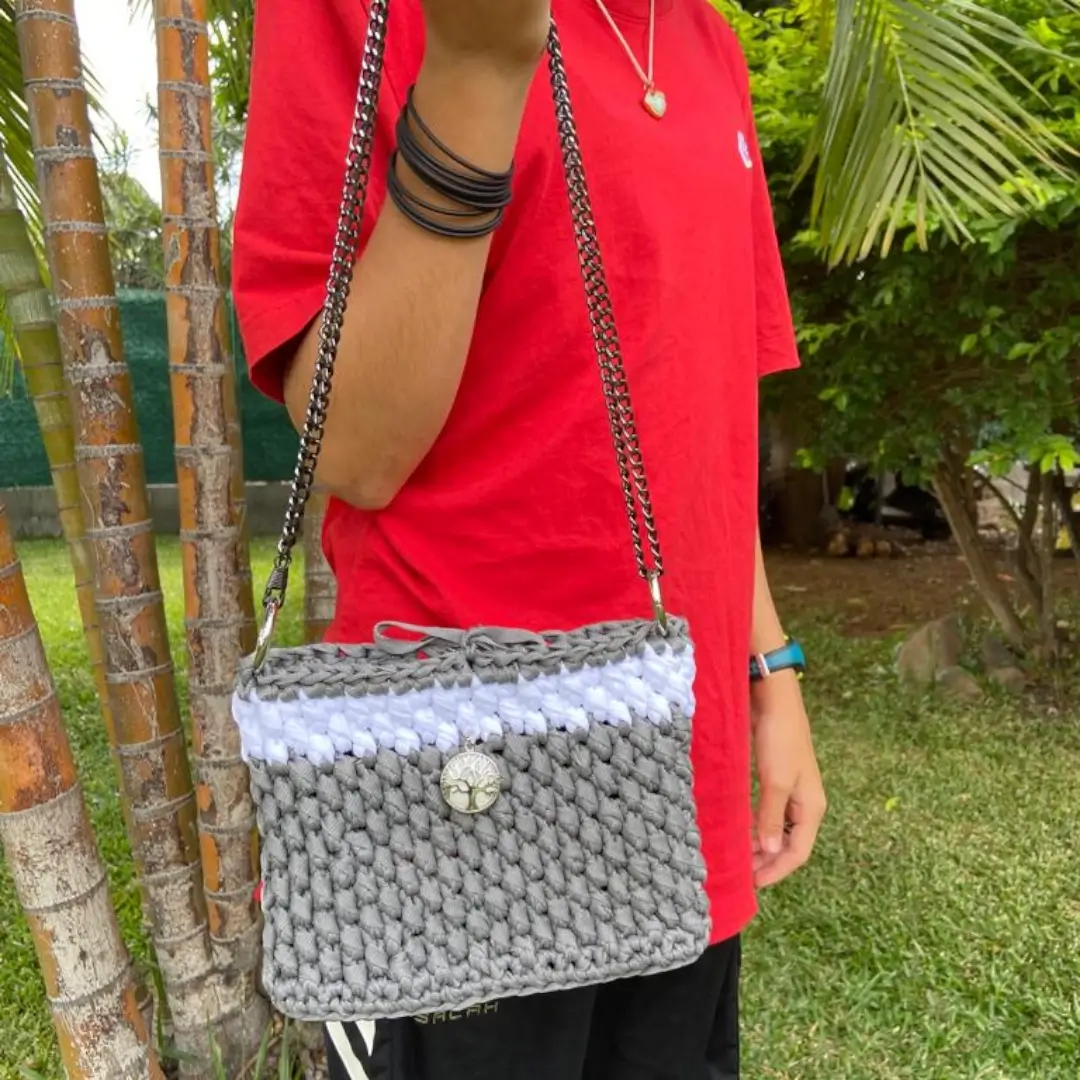 mes-crations-crochellem-galerieweb (26) Sac à bandoulière en crochet gris et blanc avec chaîne métallique et fermeture à bouton décoratif porté par Marine