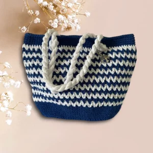 Sac cabas en crochet bleu marine et blanc avec anses torsadées.