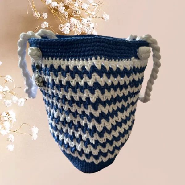 Sac cabas en crochet bleu marine et blanc avec anses torsadées, vue de profil.