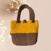 Sac cabas tricoté bicolore avec fermeture à bouton et pompon décoratif sur le côté vue de dos