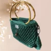 Sac à main en crochet vert émeraude avec anse en bambou et pendentif décoratif, vue de profil